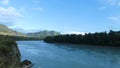 Wild mountain river. Fast water stream, hills and trees behind