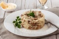 Wild mushroom risotto with parsley and parmesan on a white wooden background