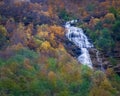 A wild Norwegian waterfall in the fall forest near the village of Geiranger