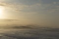 Ocean coast at sunset with waves breaking and mountains in silhouette behind