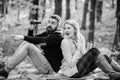 Wild outdoor. couple in love relax in autumn forest with tea or coffee. camping and hiking. surprised girl drink mulled Royalty Free Stock Photo