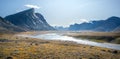 Wild Owl River winds through remote arctic landscape in Akshayuk Pass, Baffin Island, Canada. Moss valley floor and