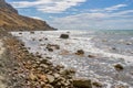 Wild picturesque seashore with pebbles and large stones Royalty Free Stock Photo