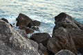Wild sea panorama surrounded with sharp rock stones in summer on sunny sunset day. Beauty and force of deep water
