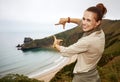Woman hiker framing with hands in front of ocean view landscape