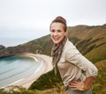 Happy adventure woman hiker in front of ocean view landscape