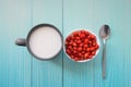 Wild strawberries in white bowl, milk in cup and silver spoon on blue wooden background, Top view. space for text. Delicious Royalty Free Stock Photo