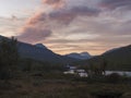 Wild Tjaktjajakka river and Kaitumjaure lake with waterfall cascade and mountains. Lapland nature landscape in summer, sunset pink Royalty Free Stock Photo