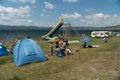 Wild tourist summer beach holiday with rubber boats and a slide in a tent camp on the background of the lake Great