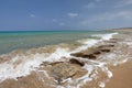 Wild unspoiled beach, sea waves hitting small rocks on sand, azure water and calm sky in background. Karpass region, Northern