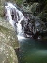 A wild waterfall between black boulders