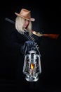 Wild west blonde girl with cold blast kerosene lantern in hand and gun