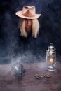 Wild west blonde girl shooting from revolver gun at the table with ammunition and silver coins Royalty Free Stock Photo