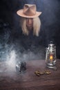 Wild west blonde girl shooting from revolver gun at the table with ammunition and silver coins Royalty Free Stock Photo