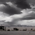 Wild west desert cloudy sky creepy scene distant wooden buildings left behind