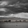 Wild west desert cloudy sky creepy scene small abandoned town in distance Royalty Free Stock Photo