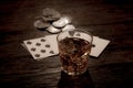 Wild west gambling. Dead man`s hand, silver coins and whiskey shot. Two-pair poker hand consisting of the black aces and black Royalty Free Stock Photo