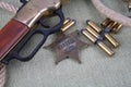 Wild west rifle, ammunition and sheriff badge Royalty Free Stock Photo