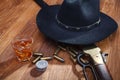 Wild west rifle and ammunitions with glass of whisky and ice with old silver dollar on wooden table Royalty Free Stock Photo