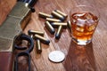 Wild west rifle and ammunitions with glass of whisky and ice with old silver dollar on wooden table Royalty Free Stock Photo