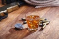 Wild west rifle and ammunitions with glass of whisky and ice with old silver dollar on wooden table