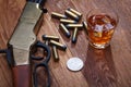 Wild west rifle and ammunitions with glass of whisky and ice with old silver dollar on wooden table Royalty Free Stock Photo