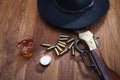 Wild west rifle and ammunitions with glass of whisky and ice with old silver dollar on wooden table Royalty Free Stock Photo