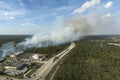 Wildfire burning severely during dry winter season in North Port city, Florida. Thick smoke rising up over suburb homes Royalty Free Stock Photo