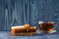 Wildflower honey on wooden table next to honeycomb with honey di