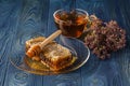 Wildflower honey on wooden table next to honeycomb with honey di