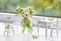 Wildflowers chamomile in a jar and miniature furniture Royalty Free Stock Photo