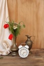 Wildflowers, red poppies in an old brass jug on an old wooden table, white alarm clock, white silk drapery, concept of time, Dutch Royalty Free Stock Photo