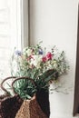 wildflowers in wicker bag on rustic white window. colorful flowers in brown basket in sunlight, space for text. rural atmospheric Royalty Free Stock Photo