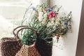 wildflowers in wicker bag on rustic white window. colorful flowers in brown basket in sunlight, space for text. rural atmospheric Royalty Free Stock Photo