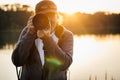 Wildlife photographer with camera photographing nature on lake at sunset Royalty Free Stock Photo