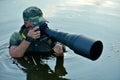 Wildlife photographer outdoor, standing in the water Royalty Free Stock Photo