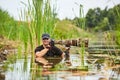 Wildlife photographer outdoor, standing in the water. Wildlife photographer in summer time working in the wild. Wildlife Royalty Free Stock Photo