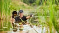 Wildlife photographer outdoor, standing in the water. Wildlife photographer in summer time working in the wild. Wildlife Royalty Free Stock Photo