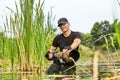 Wildlife photographer outdoor, standing in the water. Wildlife photographer in summer time working in the wild. Wildlife Royalty Free Stock Photo