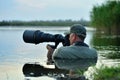 Wildlife photographer outdoor, standing in the water Royalty Free Stock Photo