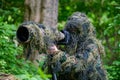 Wildlife photographer in the summer ghillie camouflage suit