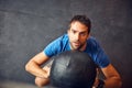It will all pay off in the end. High angle shot of a handsome young man working out with a medicine ball in the gym. Royalty Free Stock Photo