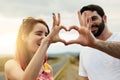 We will always be friends. two young friends putting their hands together to make a heart shape while standing outside