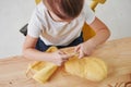 It will be such a nice cap. Kid is knitting at home. Cute little girl sitting near the wooden table is learning some new Royalty Free Stock Photo