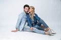 He will never let her go. Beautiful young couple bonding and smiling while sitting against grey background Royalty Free Stock Photo