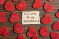 Will you be my Valentine - typed text. Valentines Day greetings concept. Little red wooden hearts close up. Valentines greeting Royalty Free Stock Photo