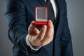 Will you marry me, A man in a business suit holds out in his hand a red box with a wedding ring. Concept of marriage proposal, Royalty Free Stock Photo