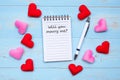 WILL YOU MARRY ME? word on note book and pen with red and pink heart shape decoration on blue wooden table background. Love, Royalty Free Stock Photo