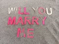 Will you marry me written on sand and partially covered by sand Royalty Free Stock Photo
