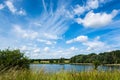 Willen lake and grasses on lakeside under blue cloudy sky in summer